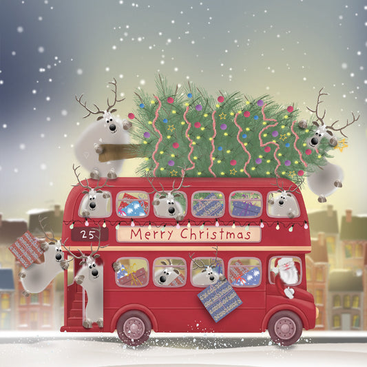 Santa and reindeer aboard a red double-decker bus carrying presents and a decorated Christmas tree through the snow