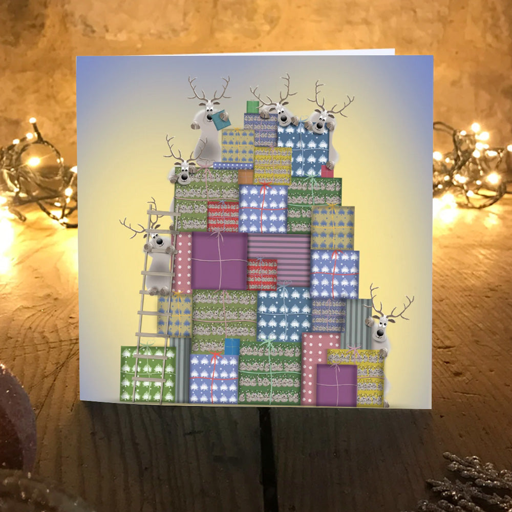 O'Dears reindeer Christmas card on a wooden table with warm fairy lights