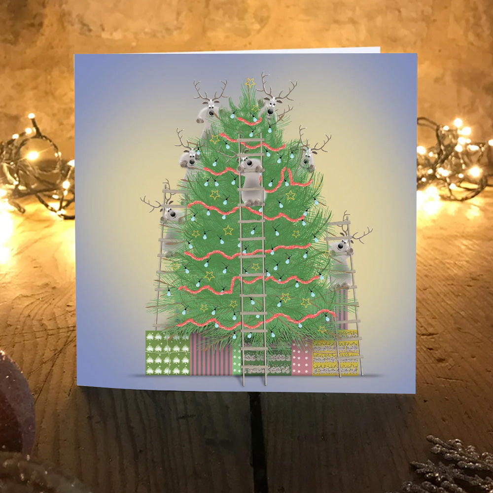 O'Dears reindeer Christmas card on a wooden table with warm fairy lights